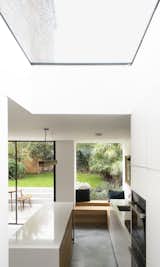 Changes of floor level and frameless roof-lights loosely divide the open-plan kitchen, dining, living and study spaces.