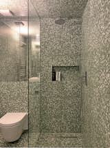 A white volume from the exterior, every surface of the interior of the  ground-floor bathroom is clad with terrazzo.
