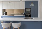 The kitchen is visually presented as an arrangement of smaller rectangular planes and volumes, in white and blue.
