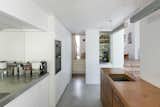 The open-plan interior is loosely divided by rectilinear volumes that continue the language of the exterior architecture at a smaller scale, concealing storage and hidden doors.
