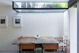 A casual dining area is nestled behind one of the blade walls that form the rear elevation is top-lit by an inverted rooflight.