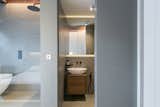 The master suite features a bath separated from the sleeping area by a full-height clear glass screen.
