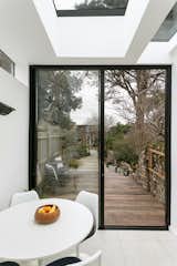A dining area is defined by the termination of the kitchen units, and a rooflight, which together create soft edges to this portion of the open-plan space.