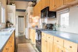 Kitchen, Wood Cabinet, Ceiling Lighting, Range Hood, Drop In Sink, Concrete Floor, Dishwasher, Microwave, Laminate Counter, Refrigerator, Accent Lighting, Recessed Lighting, and Range  Photo 11 of 22 in Marquette Modern by Jake Skinner