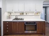 Kitchen, Wall Oven, Accent Lighting, Dark Hardwood Floor, Recessed Lighting, Subway Tile Backsplashe, White Cabinet, Refrigerator, Range, and Wood Cabinet  Photo 1 of 5 in Tudor House by FORWARD Design | Architecture