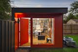 This detached home office unit by FORWARD Design | Architecture features a fire engine red exterior and ample storage within.