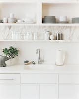 White marble seems to really class up the joint.  If it's not time for a whole new kitchen, what about this nice little shelf detail?