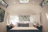 Airstream suites include queen-sized Casper mattresses with deluxe bedding. The pendant lights are from Schoolhouse Electric.  Photo 1 of 13 in Airstream Lifestyle by Stephen Blake from AutoCamp’s Modern Clubhouse Emerges from the Russian River Redwoods