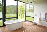 Bath, Open, Medium Hardwood, Soaking, and Freestanding The guest bathrooms are outfitted with showers and tubs that feel close to nature.  Bath Medium Hardwood Open Soaking Photos from This South African Villa Lets You Bask in Divine Views