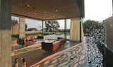 Multi-Slide Doors by Western Window Systems retract and allow the living room to enjoy the offshore breeze. The pool extends along one side, allowing the homeowners to feel as though they are floating on water.
