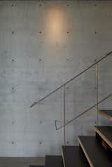 Throughout the 4,607-square-foot residence, the materials used in the built environment speak to the natural environment. Here, raw brass railings and inserts in the concrete wall plugs give off a star-like glimmer in the gallery, which originally showcased the homeowner's art collection.  Photo 4 of 14 in An Internationally Celebrated Home in the Australian Backcountry Asks $9M