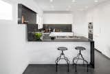In a kitchen that Brunn built for HGTV in partnership with Bosch, an understated black-and-white palette is paired with a minimal design. The project was named Wrap It Up as an allusion to the film set as well as the way the Caesarstone runs up the wall to create a shelf.  Photo 10 of 11 in Favorites by Kriszta Molnar from Designed to Disappear: The Case For the Minimal Kitchen