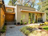 The landscaping features encore azaleas, arborvitae, and Japanese cypress. An oak forest in the backyard provides a sense of privacy and seclusion.  Photo 9 of 15 in 14 Backyard Landscape Designs That Need Minimal Maintenance from Move Into This Midcentury Modern Revival in North Carolina For $1.2M