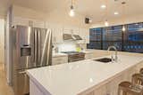 The kitchen boasts white quartz countertops and stainless steel appliances.