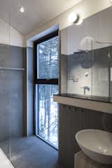 A bathroom and shower overlooks the surrounding forest.