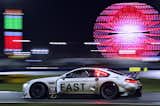 Night falls, the track is slick with rain, and the atmosphere of the infield grows more delirious as fans stay up to watch the race unfold.  Photo 10 of 12 in John Baldessari Blazes a Trail at the Daytona International Speedway With BMW Art Car #19