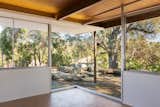 Situated on the eastern end of the residence, the master bedroom boasts a mitered glass corner window that overlooks a koi pond and a Live Oak tree.