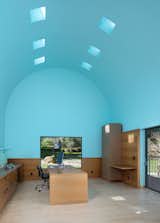 The office boasts an 18-foot, barrel-vaulted ceiling, an architectural metaphor for inspiration and exaltation. Despite only visiting the site once before embarking on the four-year design process, Sottsass precisely placed picture windows to frame available views. "The windows are not done classically," explains Michael Dreyfus, CEO of Dreyfus Sotheby's International Realty. "You can't see out of them except when you're in front of them. David literally has to stop to see outside." The old oak tree that used to stand outside fell a few years ago, but the rock preserves a sense of deliberate placement.