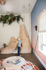 "The Great Exploration Kid's Bedroom" by Sherry Hope-Kennedy is "a space intended for climbing, hanging, and pure adventure—shelter for the seeker of all things fun and free," says the designer. Ombre wallpaper wraps around the room, providing an African backdrop to a tree fort-inspired bunk bed, carved gym rings, and a termite mound enclosure.