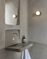 Inspiration for the powder room by David Bjorngaard and Stephen Stout came from trips to Rome and Milan. "The core concept of the bathroom is the Roman bath—the materiality of the limestone wainscot and the limestone plaster walls—and the simplicity of a Roman fountain [represented by] a simple faucet that empties into a sleek basin," says Bjorngaard.&nbsp;