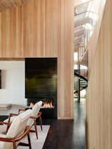 The living room Ortal fireplace is clad in cold-rolled steel with a waxed finish. The side chairs, vintage reproductions from Room and Board, feature shapely walnut arms.