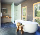 A deep soaking tub offers relaxation and views of the surrounding foliage.