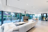 Living Room, Ribbon Fireplace, Gas Burning Fireplace, Rug Floor, Sectional, Coffee Tables, Chair, Recessed Lighting, Floor Lighting, Table, and Stools  Photo 2 of 10 in recessed lighting by martina mass from Wrapped in Galvanized Steel, ‘Cube House’ in Vancouver Asks $12.8M