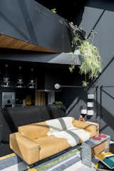 "In the open-plan living and dining space, black walls rise from engineered-oak flooring, stained a similar deep hue,