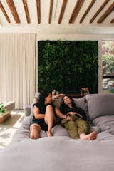 Chau (left) and Desna (right) lounge on a Timothy Oulton sofa in the living room, which takes inspiration from trendy hotel lobbies that they, as frequent travelers, often encountered. Even the CB2 desk behind them recalls a registration counter—it’s also served as a DJ booth.