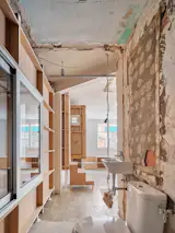 The decision to leave the finishes raw after demolition was a cost-effective and aesthetic one. The broken plaster and concrete where walls had been are a nod to the previous owner.