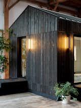 The vertical cedar slats create a sophisticated exterior that echo the outdoor sconces designed by Brendan Ravenhill that provide adjustable, dimmable light.