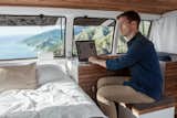 Cargo Van Mobile Studio bedroom with repurposed wood accents, Zach Both working at nightstand as a desk