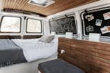 Cargo Van Mobile Studio bedroom with repurposed wood accents, window shutters folded in to show chalkboards