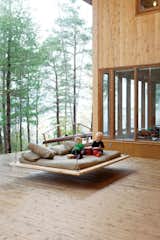 CP Harbour House is a vacation home outside of Toronto designed by MJ | Architecture with a large, bed-like swing hanging on the tree-surrounded deck.

Photo courtesy of Lorne Bridgman