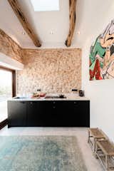 The kitchen and bathroom kept the original stone walls adding texture above the steel cabinets and marble countertop from Eginstill.

#IbizaInteriors #StandardStudios #Ibiza #CampoHouse #DesignMilk
Photos by Youri Claessens  Photo 4 of 12 in Los casas by Geo from Historic Stable Becomes a Modern Guesthouse