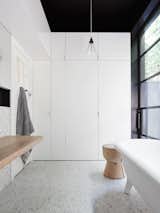 #designmilk #northbourne #architecture #melbourne #modern
Photo by Eve Wilson

The main bathroom doubles as a laundry room, which happens to be hidden behind bi-fold doors. Above the white cabinets and the ceiling are all painted black making the space feel larger.  Photo 3 of 6 in Favorites from A Melbourne Home is Renovated for a Growing Family