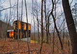 Johnsen Schmaling Architects designed the modest Stacked Cabin in a remote Wisconsin forest. Working with a tight budget, they kept the structure simple and minimized the footprint by going vertical and carving into the sloped site.