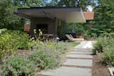 A view of the Free Float Pool House from the garden of lush plantings by Bayview Landscape Architecture.