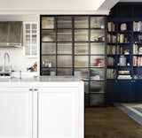 Ribbed glass in steel doors lets the light into the kitchen pantry.  The Carrara marble of the benchtop is a timeless material. 