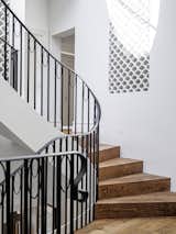 The stair rises from the entry to the bedroom level and winds up to the attic.  The simple black steel balustrade design was embellished to satisfy the required feminine touch. 