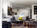 Bookcases and a television blend in amongst the owner’s collected art, including paintings by Euan McLeod and Sali Herman, and their design classic furniture pieces including a Hans J Wegner 'Papa Bear' wingback chair and ottoman. (right). To the rear of the image the lift door can be seen, integrated into a bookshelf.
© Justin Alexander