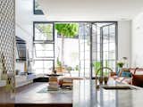 The lightwell over the living room on the left allows the morning sun to bounce down to the kitchen. Fine timber windows are designed to offer multiple uses for all seasons.
© Justin Alexander

