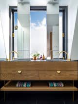 Solid American oak and brass Hafele handles are used in the vanity. Slender mirrors allow plenty of light to bathe in.
© Justin Alexander  Photo 20 of 22 in Bougainvillea Row House by Luigi Rosselli Architects