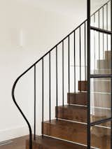 Dark oak treads and a fine classic steel balustrade provide a contrast against the white walls.
© Justin Alexander