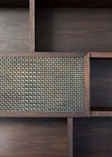 The skilled design of Edward Birch’s joinery intertwines the walnut stained shelving with woven aged brass mesh by Lockers Group.
© Edward Birch

