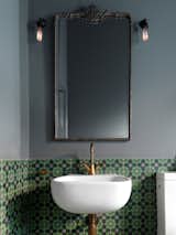 Brightly-colored encaustic tile has a matte finish that contrasts with the glossy white of the bathroom fixtures.