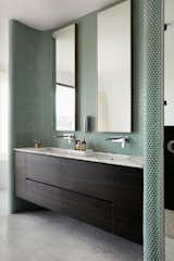 Bath Room, Marble Counter, Undermount Sink, Marble Floor, and Ceramic Tile Wall Emerald-green penny tiles line the walls in one of the sleek baths.

  Photo 13 of 16 in This Resurrected Beach Home Near Sydney Stands on a Concrete Leg from Tama’s Tee House - A Coastal Concrete Unipod