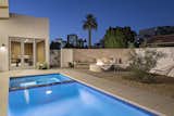 Custom firepit and concrete bench off to the side of the pool and hot tub