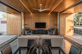 Concrete, Trees, Concrete, Ceiling, Grass, Front Yard, Living, Chair, Sofa, and Coffee Tables Walnut plywood with integrated LED lighting clad the open living space area, extending beyond the pocketing glass walls to the exterior  Living Trees Grass Ceiling Chair Photos from Favorites