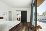 Wood floors and a matte black barn door in the master bedroom bring some of the exterior finishes into the house